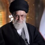 Ayatollah Ali Khamenei delivering a televised address with Iranian flag and Ayatollah Khomeini’s portrait in background
